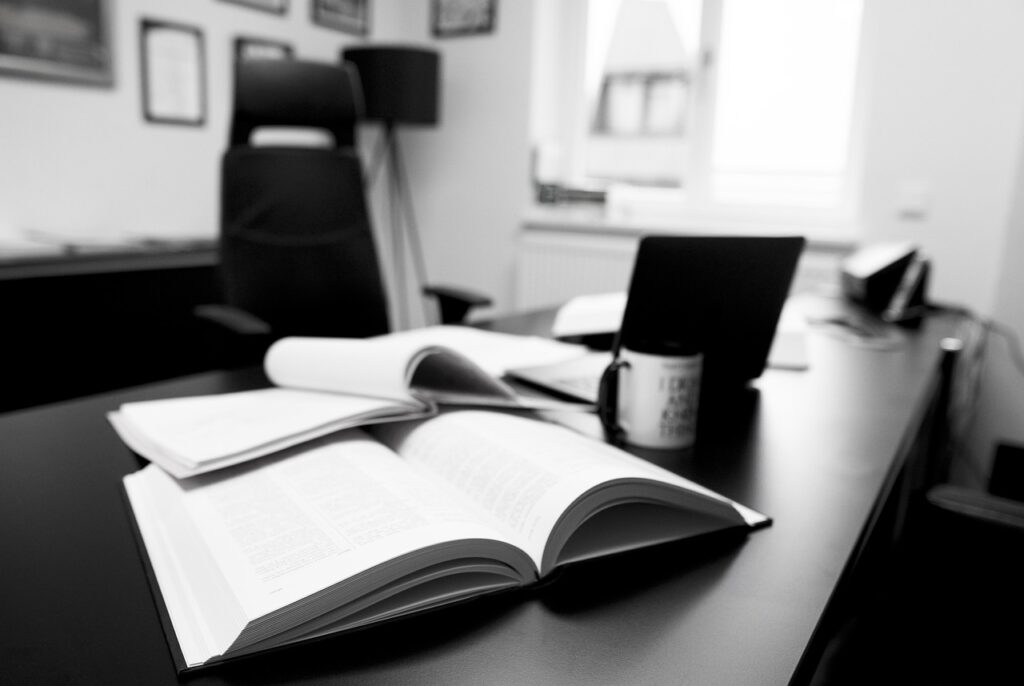 Black and white photo of an open book on a desk